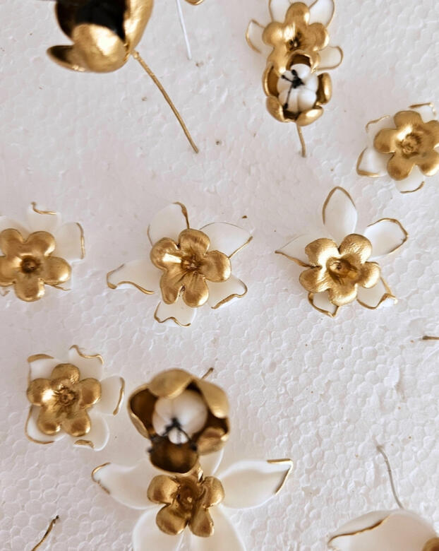 Flores artesanales hechas a mano pétalo a pétalo son moldes en porcelana fría en blanco y dorado que formarán parte de un tocado artesanal hecho a mano por Pajarita Presumida